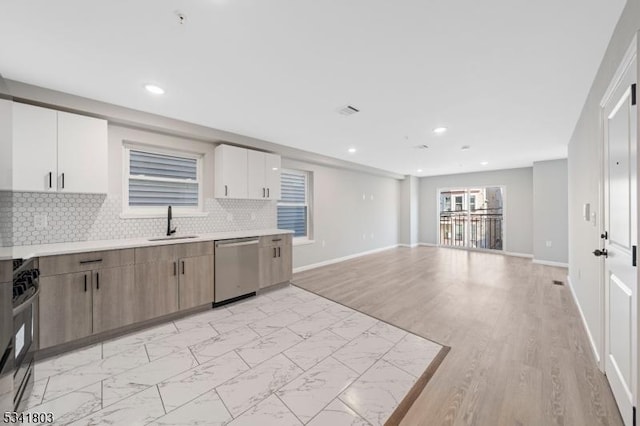 kitchen featuring light countertops, backsplash, a sink, gas range, and dishwasher