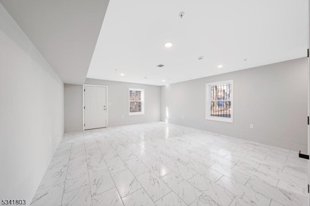 empty room featuring recessed lighting, marble finish floor, and baseboards