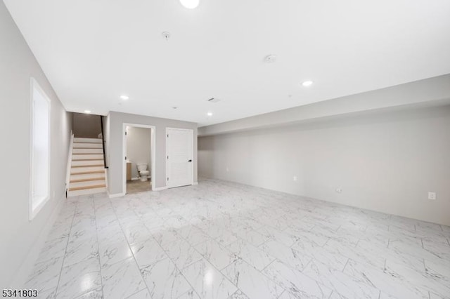 finished basement with marble finish floor, stairs, and recessed lighting