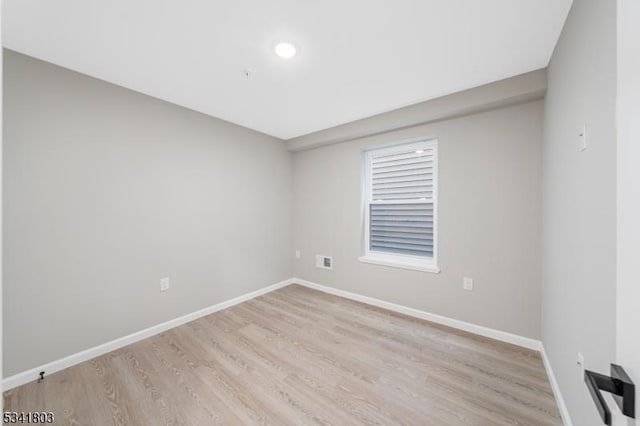 unfurnished room with light wood-type flooring and baseboards