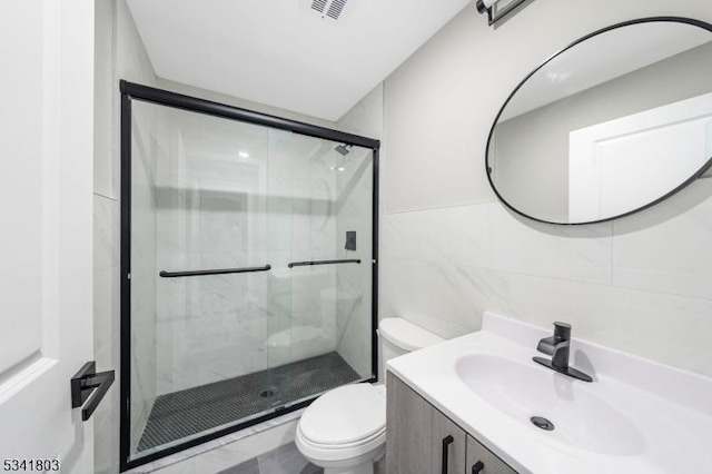 bathroom featuring toilet, a shower stall, visible vents, and vanity