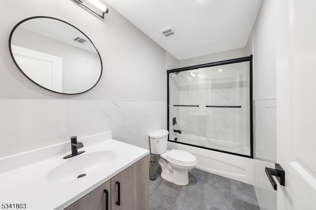 full bathroom with toilet, bath / shower combo with glass door, vanity, and visible vents