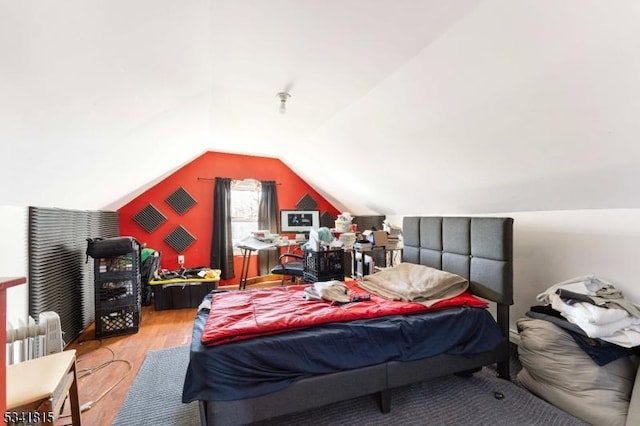 bedroom featuring lofted ceiling and wood finished floors