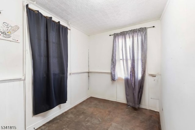 spare room with ornamental molding and baseboards