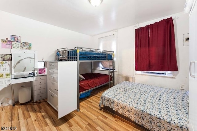 bedroom featuring radiator heating unit and wood finished floors