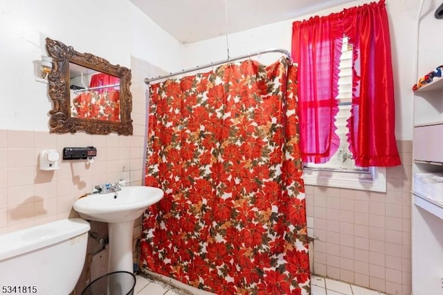 full bathroom featuring toilet, curtained shower, tile patterned flooring, and tile walls