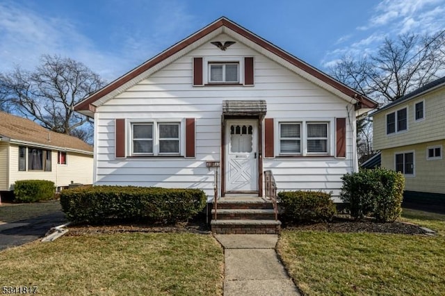 bungalow-style home with a front lawn