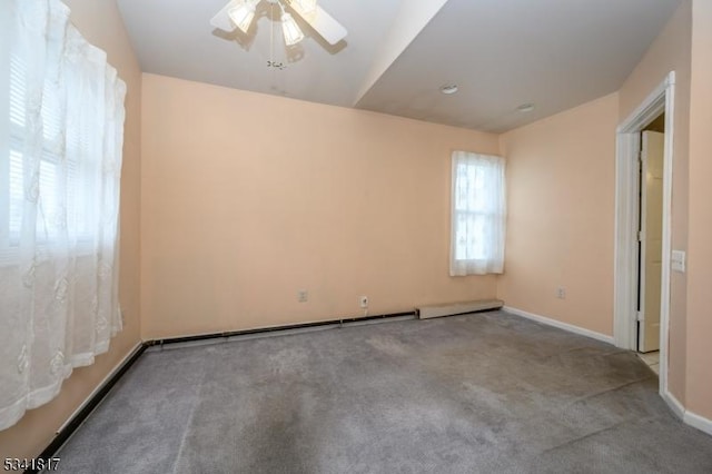 spare room featuring ceiling fan, carpet flooring, and baseboards