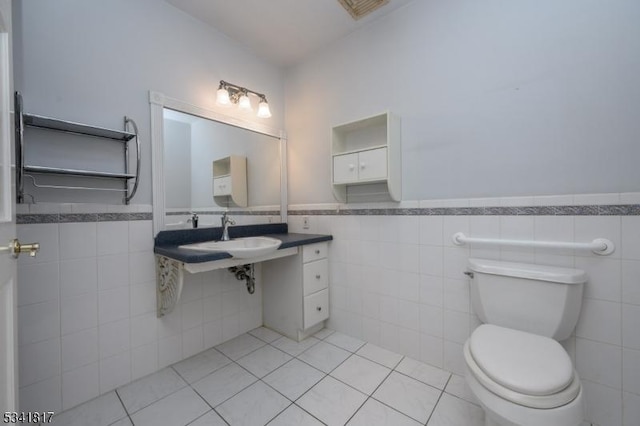 half bath featuring toilet, a wainscoted wall, tile patterned flooring, and visible vents