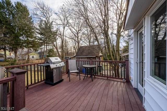 wooden deck featuring a grill