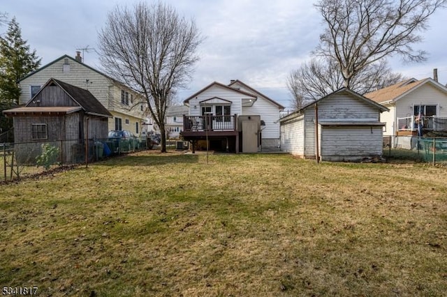 exterior space featuring an outbuilding, fence, and a wooden deck