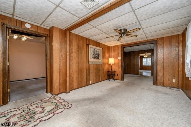 spare room featuring ceiling fan, visible vents, and wooden walls