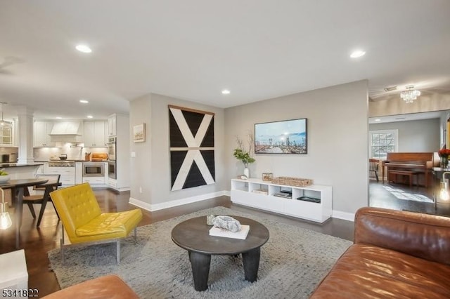 living area with baseboards, dark wood-style flooring, decorative columns, and recessed lighting