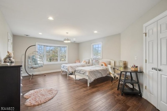 bedroom with dark wood-type flooring, a closet, recessed lighting, and baseboards