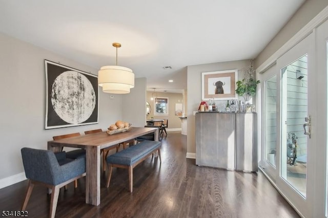 dining area with dark wood-style floors, visible vents, and baseboards