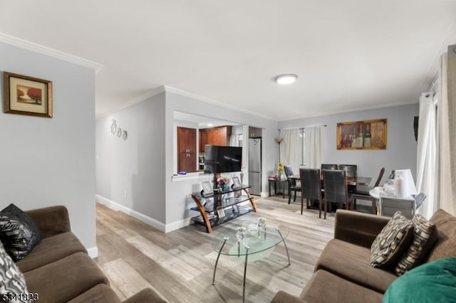 living area with light wood-type flooring, baseboards, and crown molding