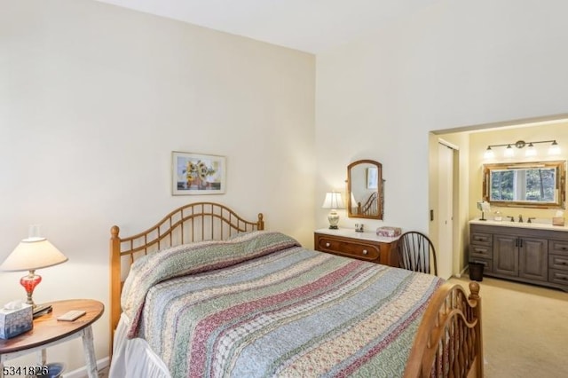 bedroom with connected bathroom and light colored carpet