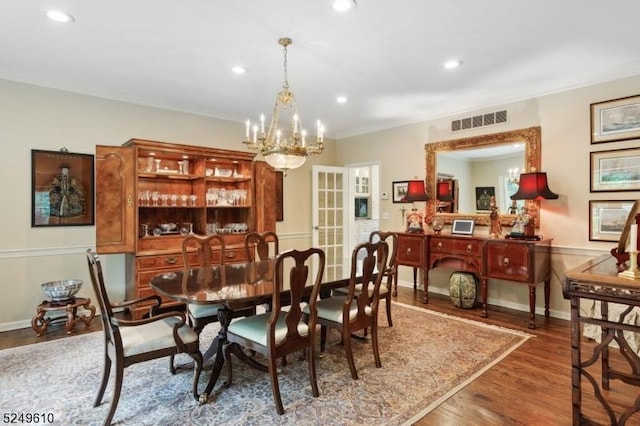 dining space with baseboards, wood finished floors, visible vents, and recessed lighting