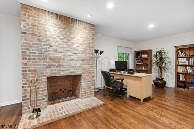 office featuring a fireplace, wood finished floors, and baseboards