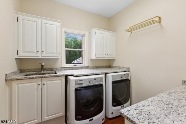 laundry room with cabinet space, a sink, and separate washer and dryer