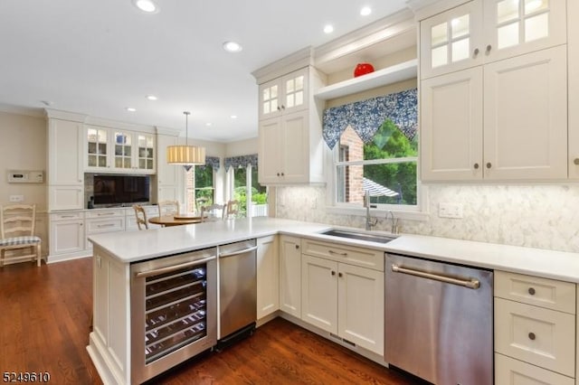 kitchen with a sink, beverage cooler, a peninsula, and dishwasher