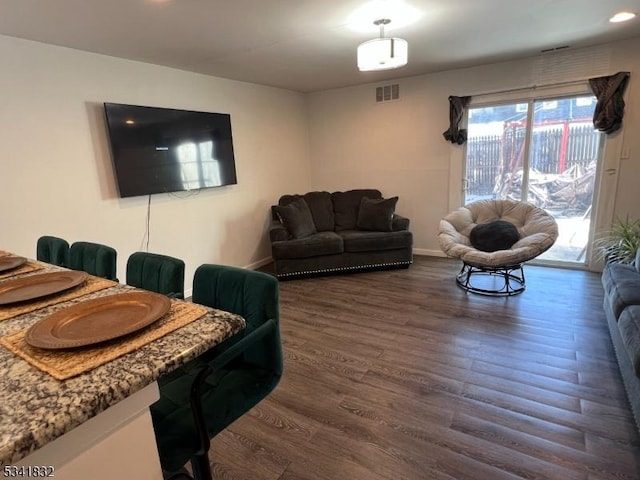 living area featuring dark wood finished floors, visible vents, and baseboards