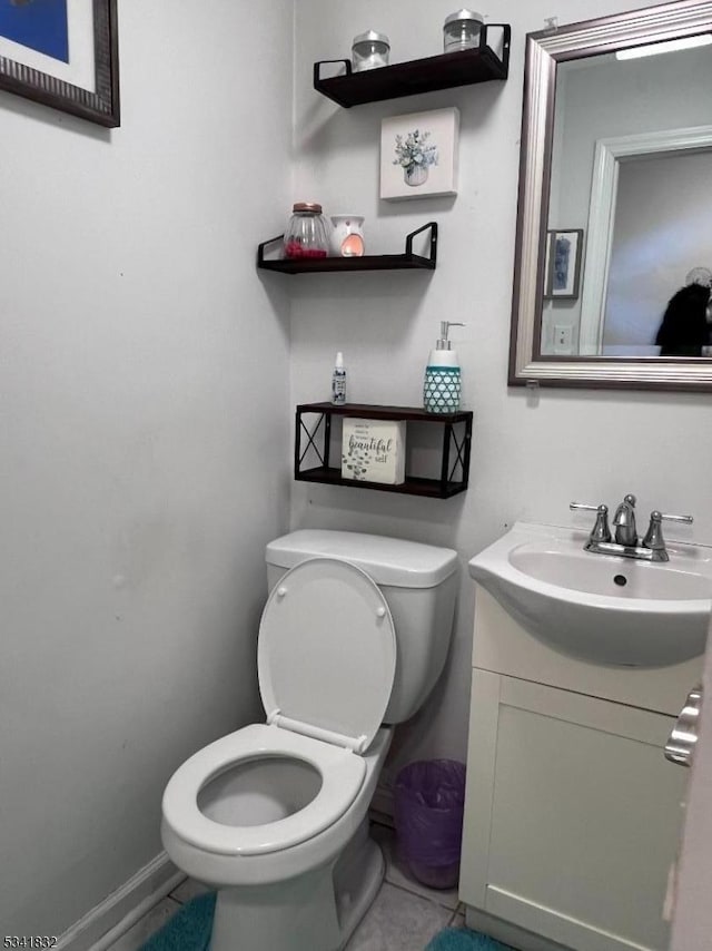 bathroom with baseboards, vanity, toilet, and tile patterned floors