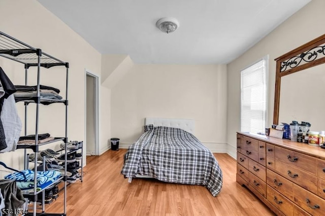 bedroom with light wood-style floors and baseboards