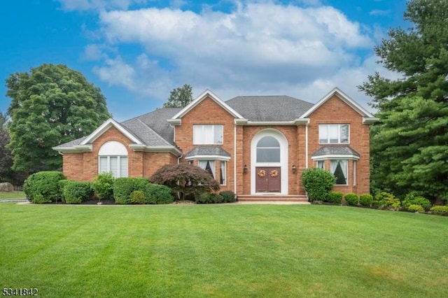 view of front of property featuring brick siding and a front yard