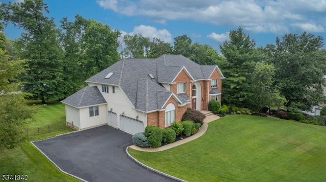 view of front of house featuring fence, a front lawn, a garage, aphalt driveway, and brick siding