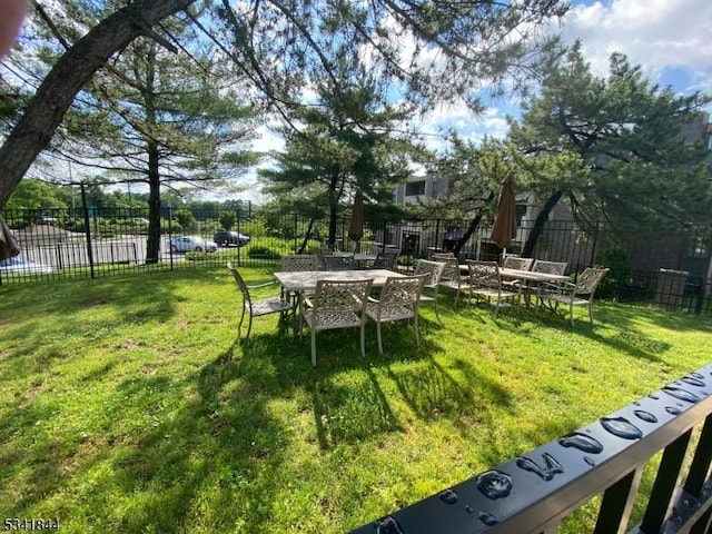 view of yard with fence and outdoor dining area