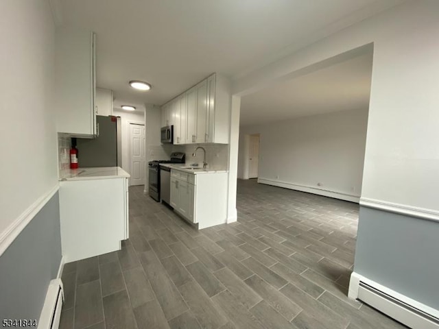 kitchen featuring a baseboard radiator, baseboard heating, stainless steel appliances, and light countertops