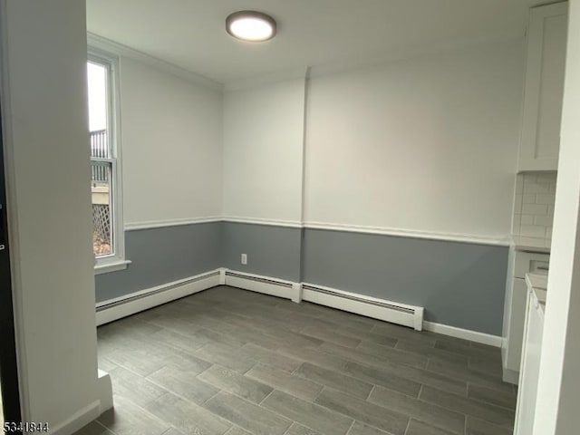 unfurnished room featuring baseboards, wood finished floors, and ornamental molding