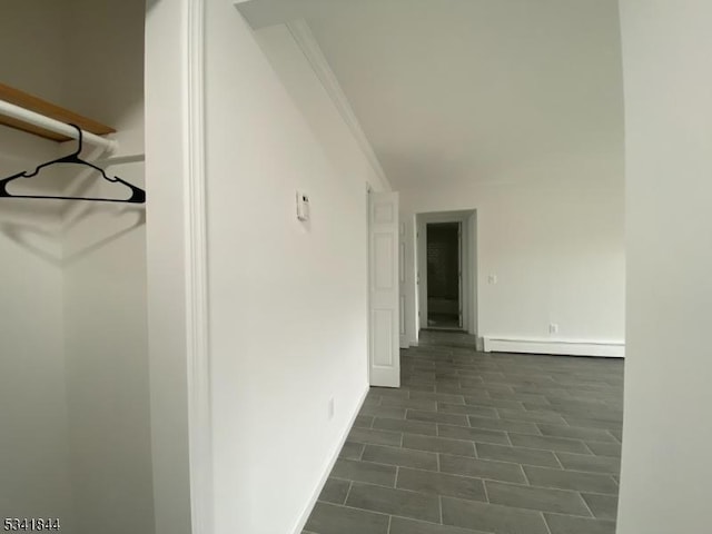 hallway with baseboards, baseboard heating, and crown molding