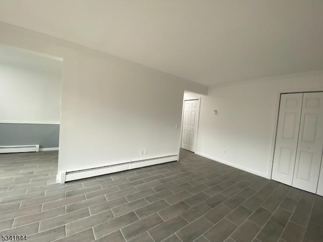 unfurnished room with baseboards and a baseboard heating unit