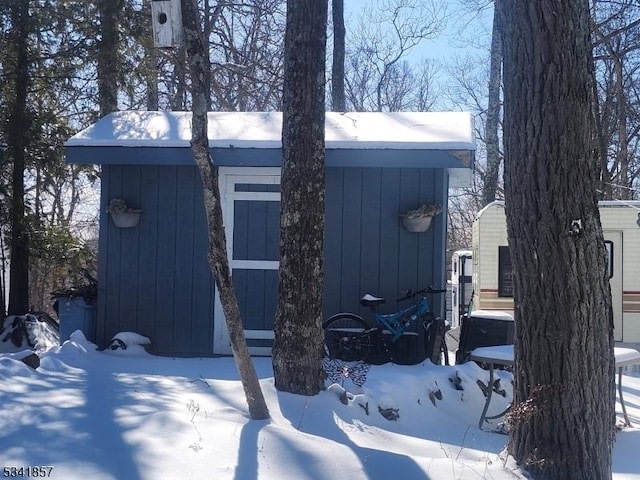 snow covered structure featuring a garage