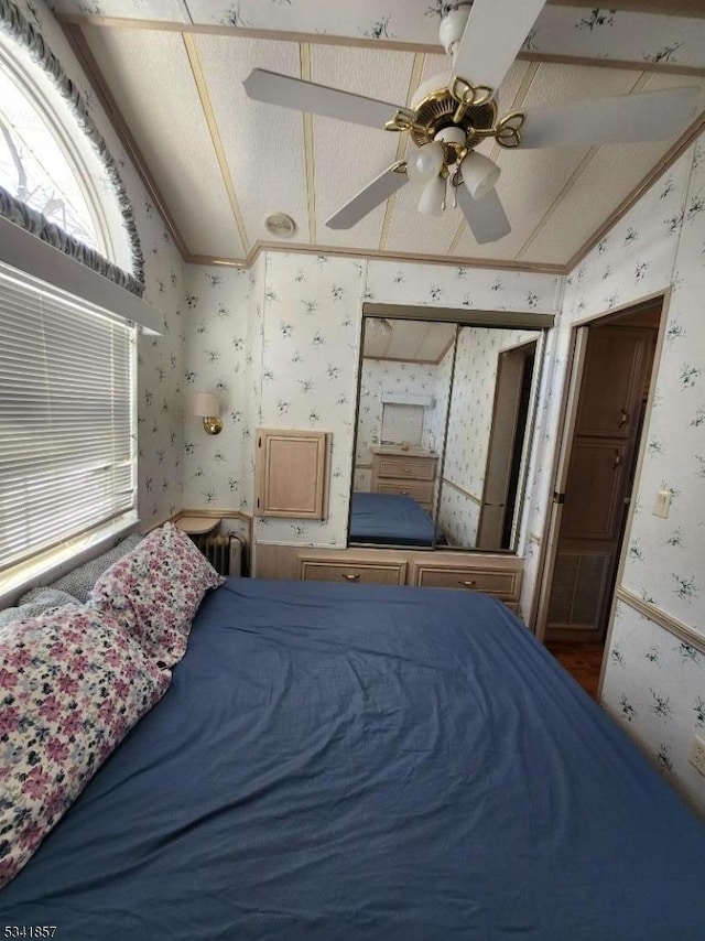 bedroom with wallpapered walls, vaulted ceiling, and ornamental molding