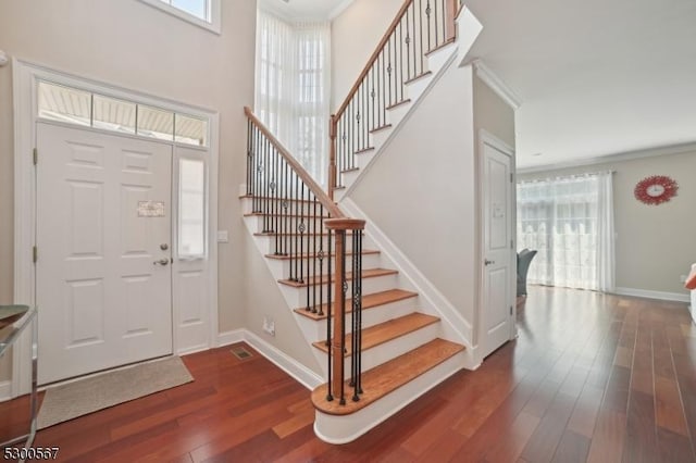 entrance foyer featuring plenty of natural light, baseboards, and dark wood-type flooring