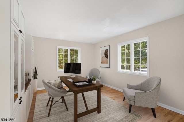 office space featuring baseboards and light wood finished floors