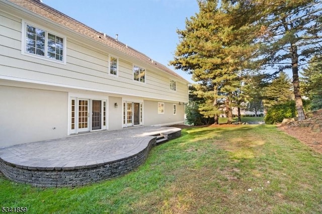 rear view of property with french doors, a patio, and a lawn