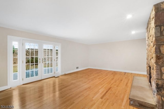 unfurnished living room with light wood-style flooring, recessed lighting, visible vents, baseboards, and french doors