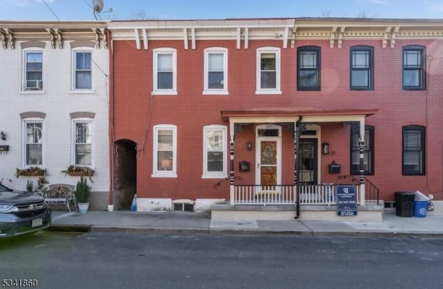 view of front of home featuring brick siding and a porch