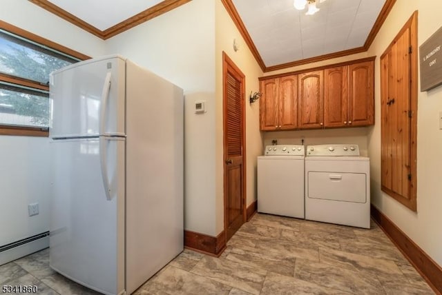 clothes washing area with baseboards, ornamental molding, baseboard heating, cabinet space, and washing machine and clothes dryer