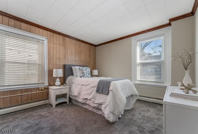 carpeted bedroom with wooden walls, a baseboard heating unit, and crown molding