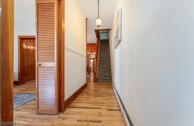 hall with stairs, light wood finished floors, and a baseboard radiator