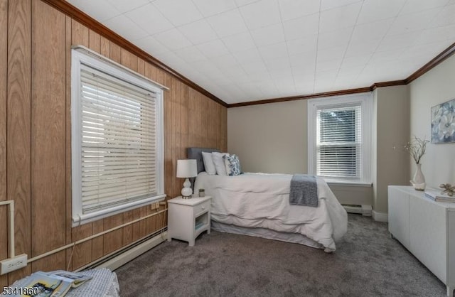 bedroom featuring ornamental molding, a baseboard heating unit, carpet flooring, and wood walls