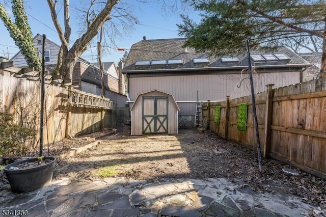 view of yard featuring an outbuilding, a fenced backyard, and a storage unit