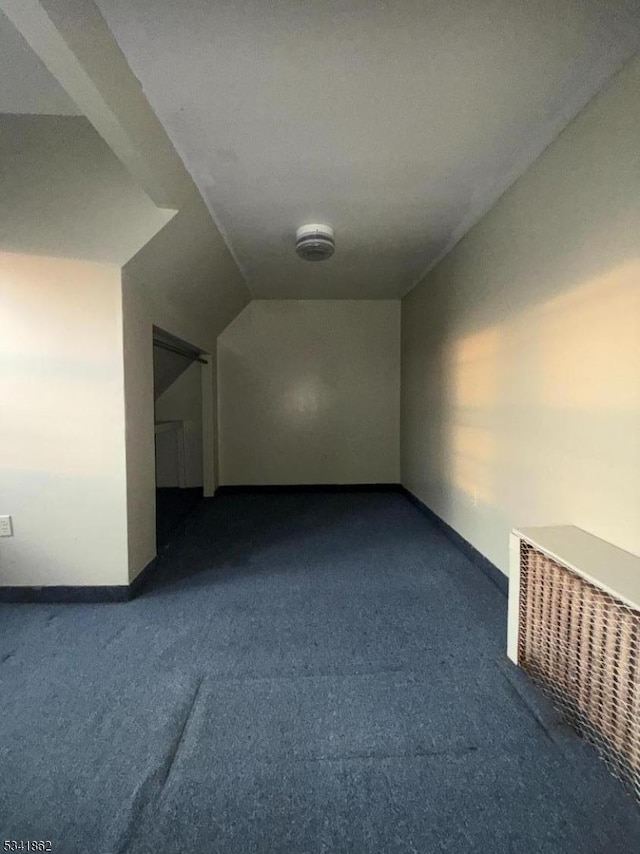 bonus room with lofted ceiling, baseboards, and dark colored carpet