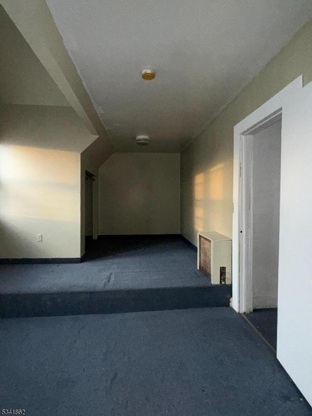 corridor featuring carpet and lofted ceiling