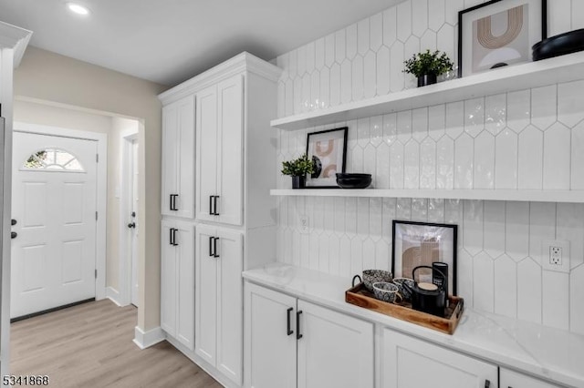 interior space featuring backsplash, light wood-style flooring, and recessed lighting